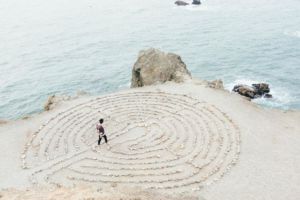 a person walking a labyrinth in the sand