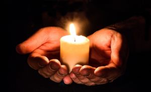 hands holding candle light in darkness hope mental health